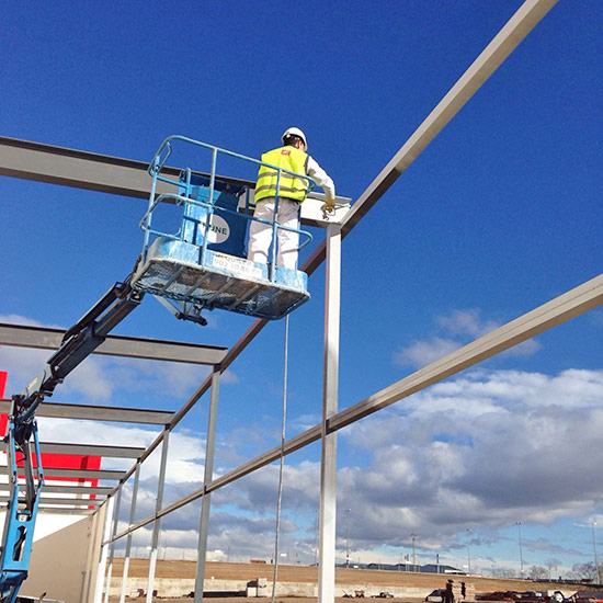 Técnico aplicando protección ignífuga sobre estructura metálica